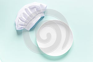 White empty plate with copy space for yout text and chef cap above.