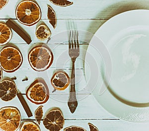 White empty plate with a fork on a white vintage wooden surface,