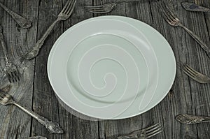 White empty plate on a gray wooden surface