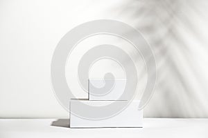 White empty stands on light shadow background. Blank unbranded shopfront. Showcase for cosmetic products. Product