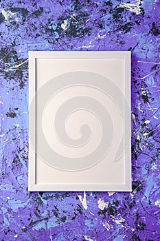 White empty template picture frame on textured blue and purple background, top view