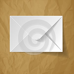 White envelope on a crumpled paper brown background.