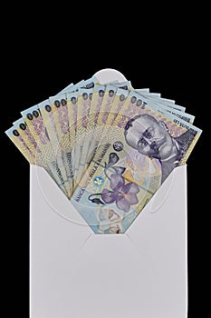 White envelope full of money on a black background. Romanian leu. Banknotes of 100 lei