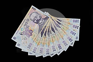 White envelope full of money on a black background. Romanian leu. Banknotes of 100 lei