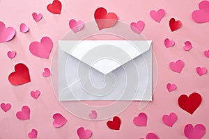 White envelope with pink background with paper cutouts of hearts