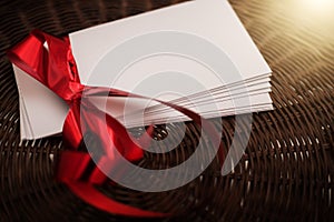 White envelope with red ribbon on wicker basket