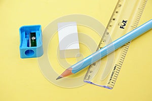 The white eraser ,scale sky colour sharpner with wooden pencil   isolated in yellow background