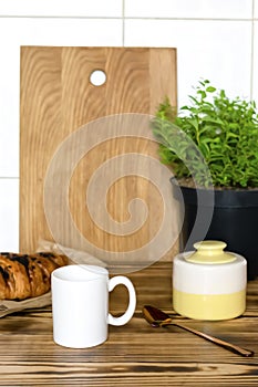 white espresso coffee cup, fresh baked croissant on kitchen table, counter, utensils dishware, home green plant in pot