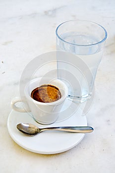 White espresso cup and glass of cold water