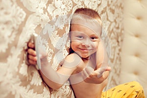 White European 5 years old boy lying on the bed in the bedroom w