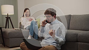 White European man and woman talking on the phone in the room