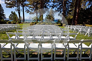 White event chairs in scenic garden by a lake