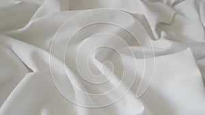 White fabric. Drapery wavy texture white linen cloth background on morning sunshine. Clean clothes concept.