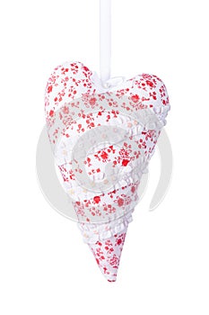 White fabric heart with red flowers on a satin ribbon isolated on white.