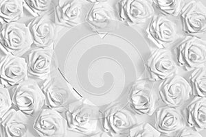 White fabric roses surrounding a love heart blank textured paper for copy space