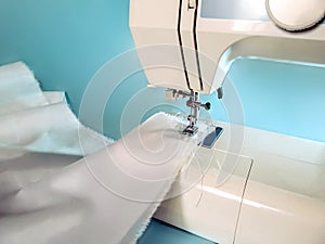 White fabric tucked into a sewing machine