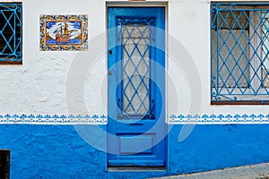 White facade and blue door of a rural house in a small Mediterranean village