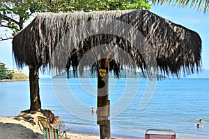 A white-faced scowl sculpted in the thatch kiosk