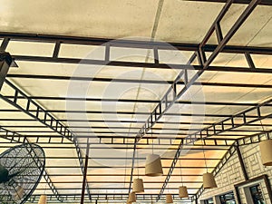 White false ceiling with black plastic slats. small, cream-colored chandeliers are attached to the ceiling, a fan for fresh air