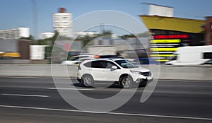 White family car quickly goes on road