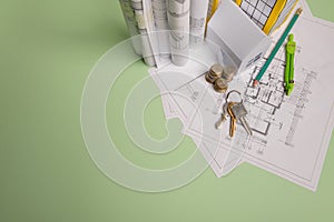 White family paper house. House keys in hand on mint background paper. Minimalistic and simple concept, style. Copy space.