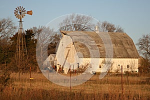 White farm barn beside a windmill