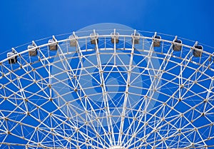 white Ferris wheel on background a clear blue sky in amusement park at fair in summer