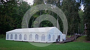 A white festive tent set up on a summer day on a forest site