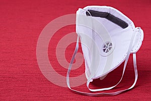 White ffp3 face mask with a valve on a red background photo