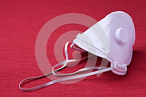 White ffp3 face mask with a valve on a red background photo