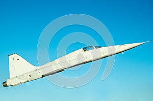 White fighter plane on a clear blue sky background