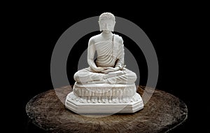 White figurine of siddhartha gautama buddha sculpture statue with dark background