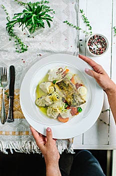 White fish with herbal oil. Mashed potatoes with olives and mixed vegetables - cauliflower, carrots, tomatoes and Brussels sprouts