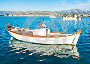 White fishing boat with greek flag in Naflpio harbor in Greece