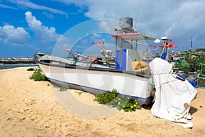 White fishing boat on the sandy shore