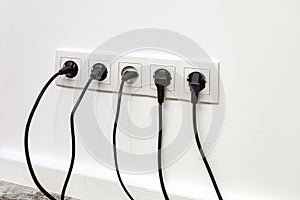 White five-way wall power socket on white wall