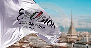 The white flag with the Eurovision Song Contest 2022 logo waving in the wind with blurred landscape of Turin