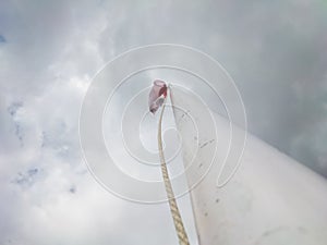 a white flagpole with a red and white flag flying