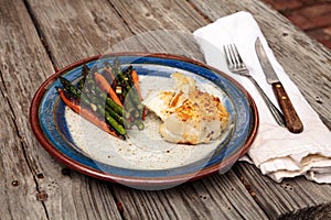 White flakey sea bass with breadcrumbs and roasted asparagus and