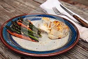 White flakey sea bass with breadcrumbs and roasted asparagus and