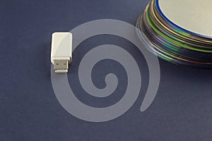 White flash drive and a stack of CD, DVD, computer, White flash drive and a stack of CD, DVD, computer