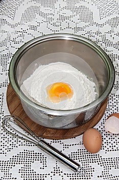 White flour in the bowl with egg yolk