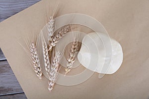 A white flour bun and a few ripe wheat ears