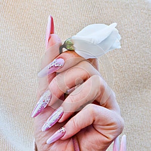 white flower offered with hands with nails with Christmas decorations