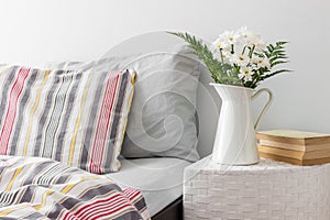 White flowers and books on a bedside table