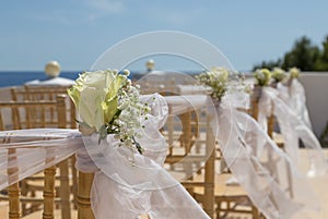 White flowers on chairs before a wedding ceremony