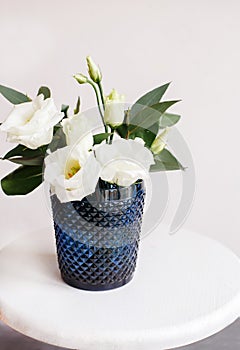 White flowers in classic blue glass. Lisianthus. Eustoma