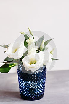 White flowers in classic blue glass. Lisianthus. Eustoma