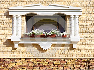 White flowers hangs on the window of a home in an ancient buildi