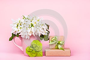 White flowers on pink background. Flowers, origami heart and gift box.